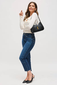Woman holding a black handbag against a white background