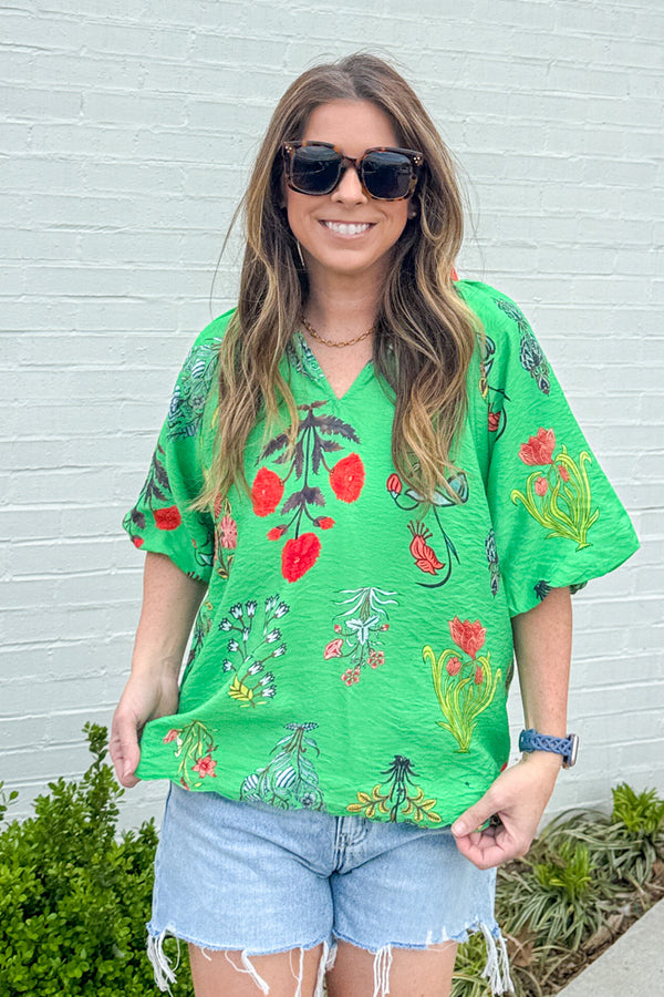 Woman wearing Bold And Beautiful bright green floral puff sleeve top by Umgee with V-neck